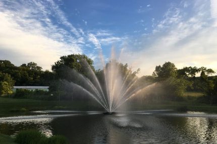 Большой аэрационный фонтан Equinox от компании Otterbine в сумерках